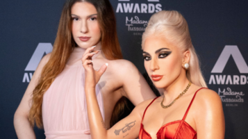 Eine Frau in einem Kleid steht neben der Wachsfigur von Lady Gaga im Madame Tussauds. Lady Gaga trägt ein auffälliges rotes Kleid und zeigt ihre "Paw"-Geste, die sie für ihre Little Monsters bekannt gemacht hat.