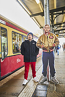 Der lebensgroße Aufsteller von Romano steht am Bahnhof neben der eingefahrenden S-Bahn