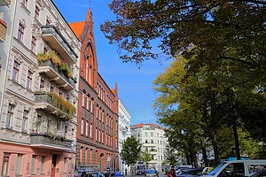 Ein historisches Schulgebäude mit roter Backsteinfassade, hohen Fenstern und verzierten Spitzbogen-Elementen im Stephankiez, Moabit.